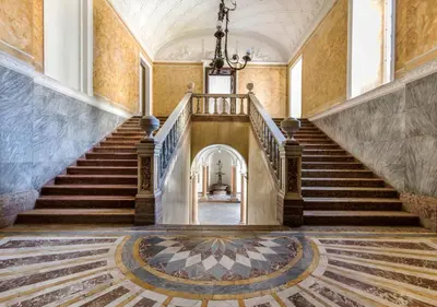 an empty staircase in a building with a chandelier at La Suite del Principe con parcheggio incluso in Palermo