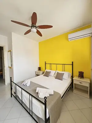 a bedroom with a bed with a ceiling fan at Appartamento Girasole in San Vito lo Capo