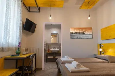 a room with two beds and a bathroom with a sink at B&B L'Officina di Apollo in Mondello