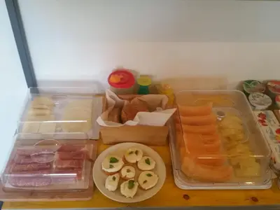 a table topped with plastic containers filled with different types of food at B&B L'Officina di Apollo in Mondello