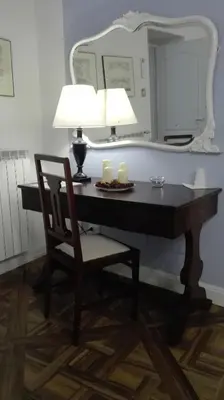 a desk with a chair and a lamp and a mirror at Demetra Rooms in Palermo