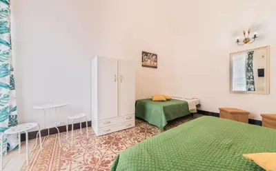 a bedroom with two beds and a white cabinet at Voilà Rooms Guest House in Terrasini