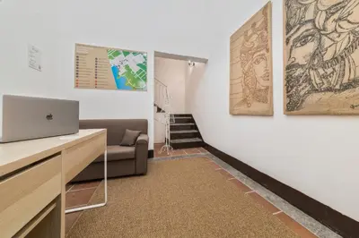 a living room with a couch and a laptop on a desk at Voilà Rooms Guest House in Terrasini