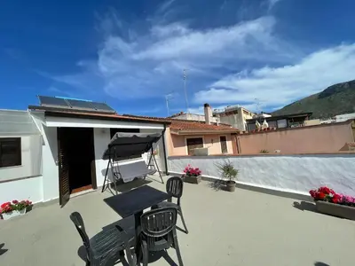 a patio with a table and chairs on a roof at Voilà Rooms Guest House in Terrasini