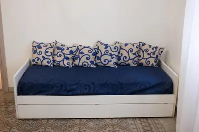 a bed with blue and white sheets and pillows at A Casa Di Lilly in Palermo
