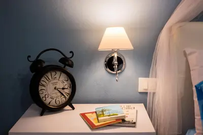 a clock sitting on a table next to a lamp at A Casa Di Lilly in Palermo
