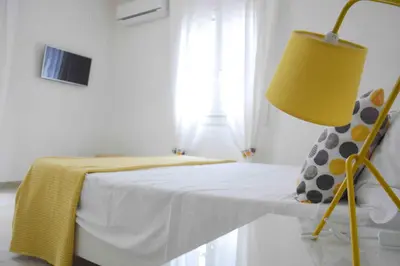 a bedroom with a bed with a yellow lamp at Villa Almyra in San Vito lo Capo