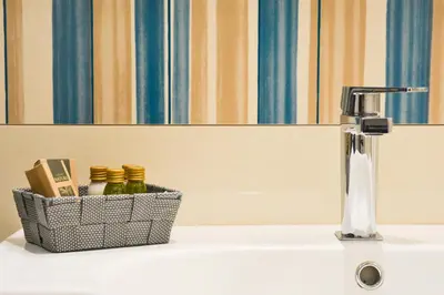 a sink with a faucet and a basket on it at Villa Almyra in San Vito lo Capo