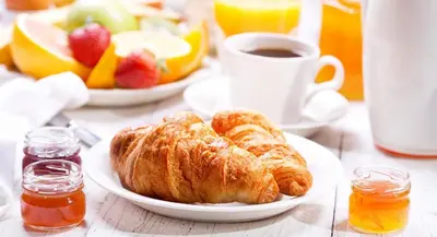 a table with a plate of pastries and a cup of coffee at Nonna Giò House in Castellammare del Golfo