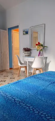 a bedroom with a bed and a table and chairs at Nonna Giò House in Castellammare del Golfo