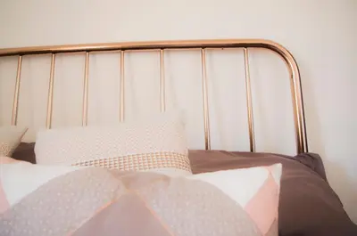 a bed with a metal head board with pillows on it at Chibedda Dimora Cesca in Castellammare del Golfo