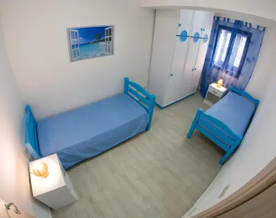 a room with two blue beds and a lamp at Light Blue in Balestrate