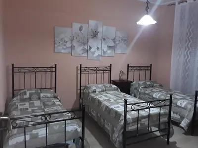a room with three beds and two paintings on the wall at Elimo Affittacamere - Casa Vacanze di Scardino Leonardo in Poggioreale