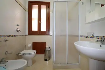 a bedroom with a large bed with a red blanket at casa Vincenzo in Castelluzzo