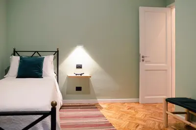 a bedroom with a bed and a light next to a door at Palazzo Planeta in Palermo