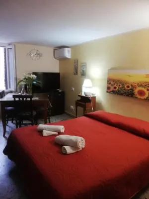 a bedroom with a red bed with two towels on it at Monolocale La Chicca in Castellammare del Golfo
