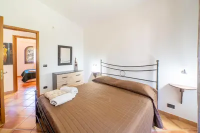 a bedroom with a large bed and a mirror at Villa Eden con piscina a Scopello in Castellammare del Golfo