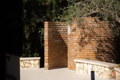 a brick wall with two benches in front of it at Villa Eden con piscina a Scopello in Castellammare del Golfo