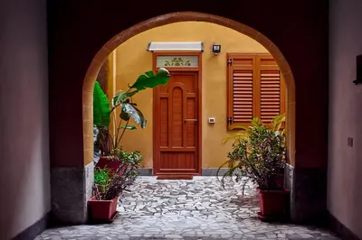 an archway leading to a house with a red door at Palermo al Centro - Appartamento Maestri in Palermo