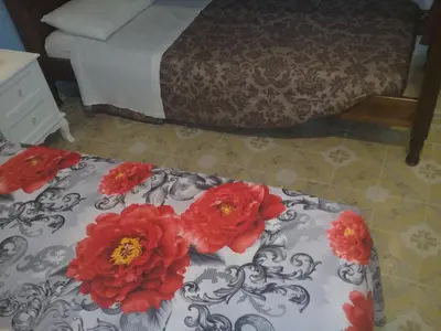 a bed with red flowers on top of it at I Cinque Continenti in Palermo