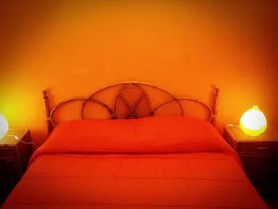 a bedroom with a red bed with two lights on it at I Cinque Continenti in Palermo