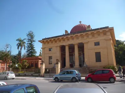 a building with cars parked in front of it at I Cinque Continenti in Palermo