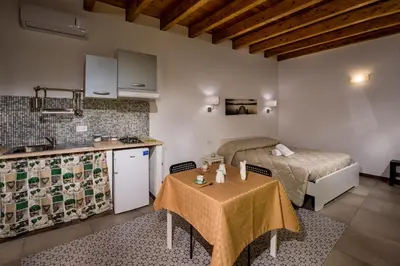 a kitchen and a bedroom with a bed and a table at Il Cortile in Castellammare del Golfo