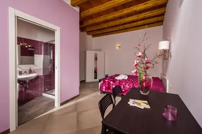 a room with a table and a room with a bathroom at Il Cortile in Castellammare del Golfo