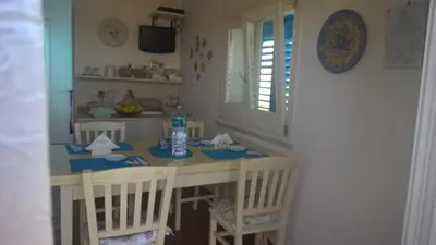 a kitchen with a table and chairs and a window at Villa Ancora Bed & Breakfast in San Vito lo Capo