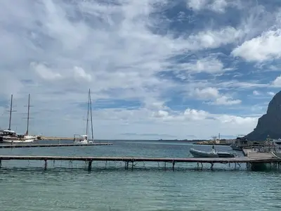 a dock in a body of water with a boat at Villa Ancora Bed & Breakfast in San Vito lo Capo