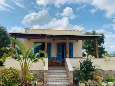 a house with blue shutters and a porch at Villa Ancora Bed & Breakfast in San Vito lo Capo