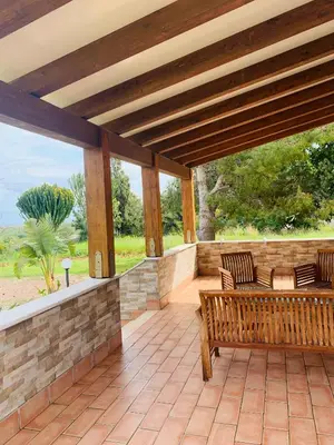 a patio with a bench and a stone wall at Villa Ancora Bed & Breakfast in San Vito lo Capo