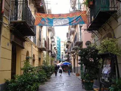 a narrow alley with people walking down the street at Casa Matrangela in Palermo