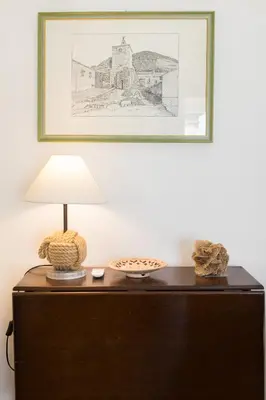 a table with a lamp and a picture on the wall at Overseas - Penthouse with terrace - Attico - Palazzo San Matteo in Palermo