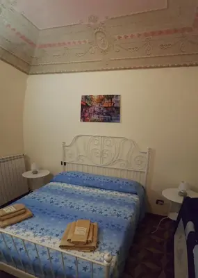 a bedroom with a bed with a blue comforter at CasaLù in Palermo
