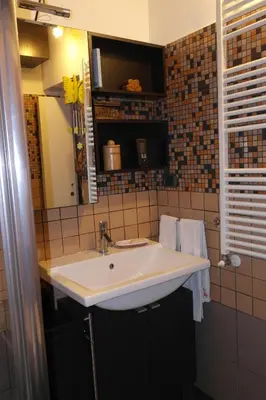 a bathroom with a white sink and a mirror at CasaLù in Palermo
