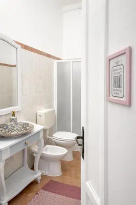 a white bathroom with a toilet and a sink at B&B 091 in Palermo