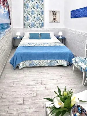 a bedroom with a bed with blue sheets and two tables at B&B 091 in Palermo