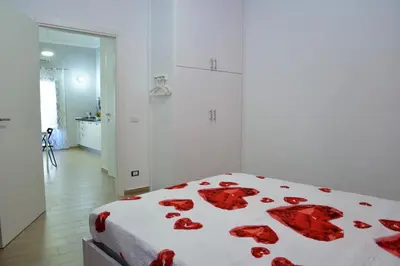 a bedroom with a bed with red roses on it at Casa Tiziana in Castellammare del Golfo