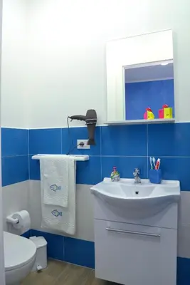 a blue and white bathroom with a sink and a toilet at Casa Tiziana in Castellammare del Golfo