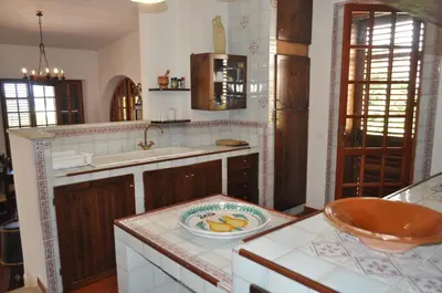 a kitchen with a bowl of fruit on a counter at Villa Hibisco in San Vito lo Capo