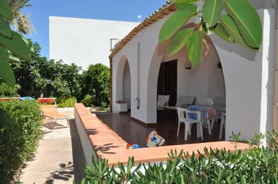 a patio of a house with a table and chairs at Villa Hibisco in San Vito lo Capo