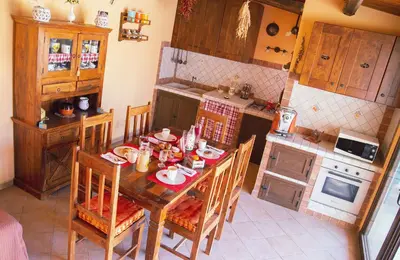 a kitchen with a wooden table and chairs in it at B&B Il Girasole in Balestrate