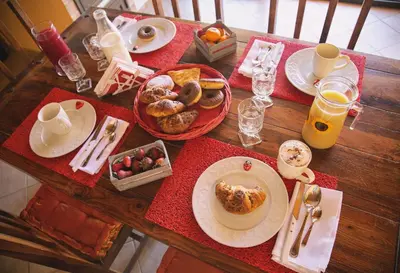 a wooden table with plates of breakfast food on it at B&B Il Girasole in Balestrate