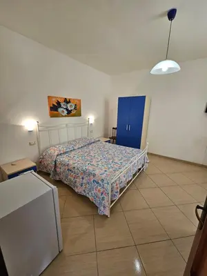 a bedroom with a bed and a blue cabinet at New Eden in San Vito lo Capo