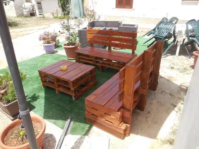 a group of wooden benches sitting in a yard at New Eden in San Vito lo Capo