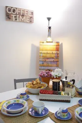 a table with plates and cups and bowls of food at Casa Gaia Palermo in Palermo