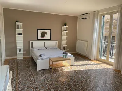 a bedroom with a bed and a table on a rug at Le Stanze di Federico apartment e Costanza Luxury apartment in Palermo