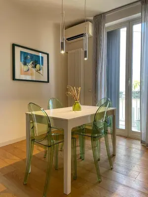 a dining room with a table and green chairs at Le Stanze di Federico apartment e Costanza Luxury apartment in Palermo
