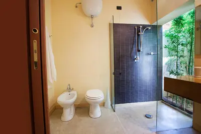 a bathroom with a toilet and a glass shower at Villa Sole in San Vito lo Capo